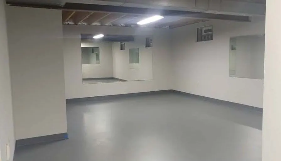 Basement remodeling — a finished basement with painted walls, floor and wall mirrors