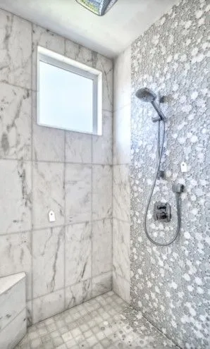 Marble shower with a pearl glass penny round mosaic feature wall