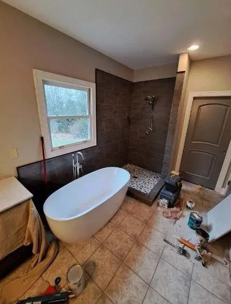 Bathroom renovation nearing completion with a freestanding tub and slate tile shower