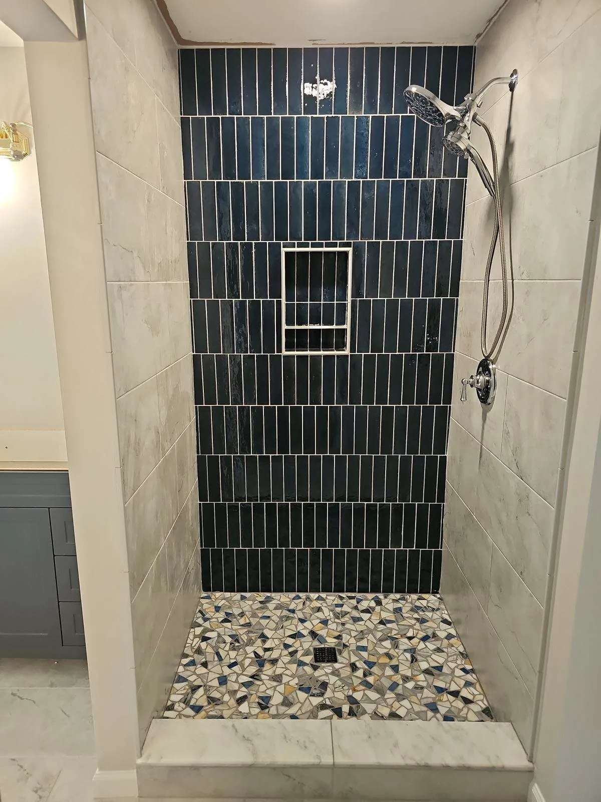 Bathroom remodeling near Cincinnati — a walk-in shower in deep teal stacked tile with a mosaic pan