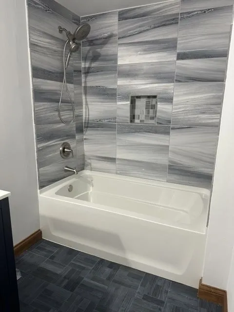Bathroom remodel with a marbled large-format tile tub surround and a mosaic niche
