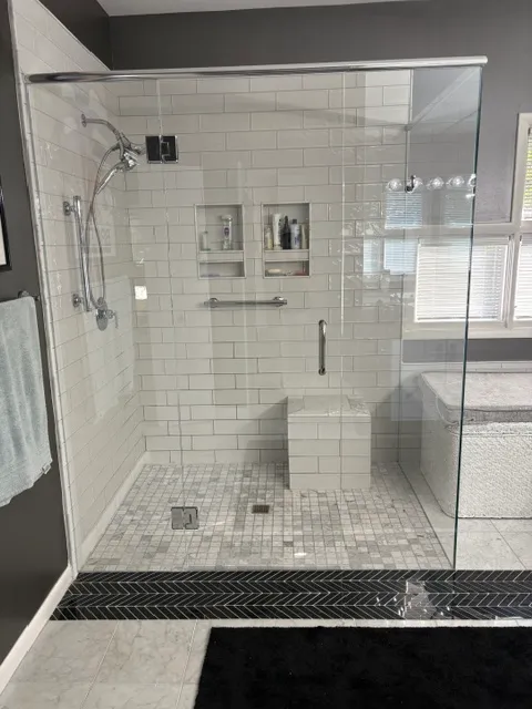 White subway tile walk-in shower with a recessed niche