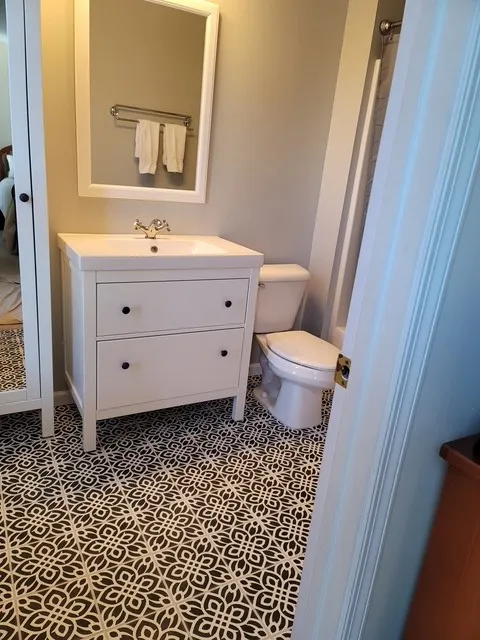Powder room with a white vanity over a bold black and white encaustic pattern floor