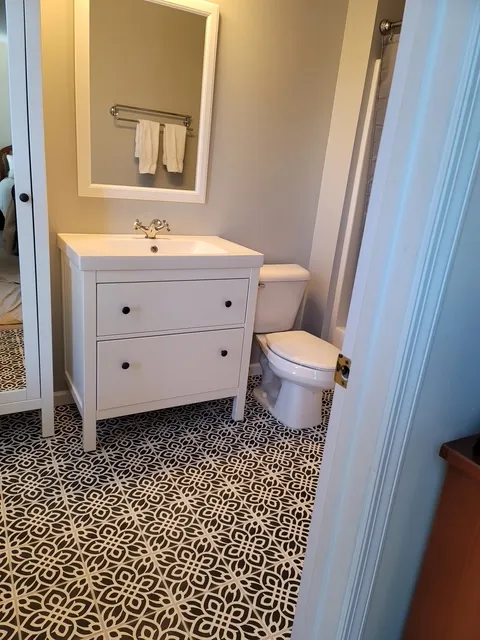 White vanity above a patterned tile floor