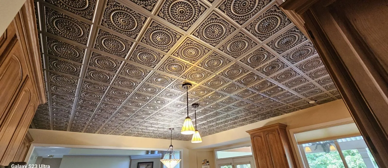 Decorative gold tin-look coffered ceiling installed in a remodeled kitchen