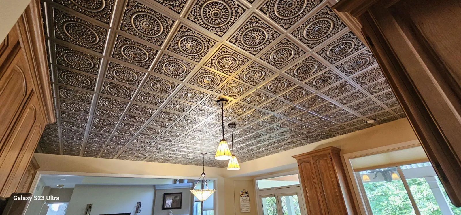 Pressed tin-look ceiling panels in a medallion pattern above a pendant light