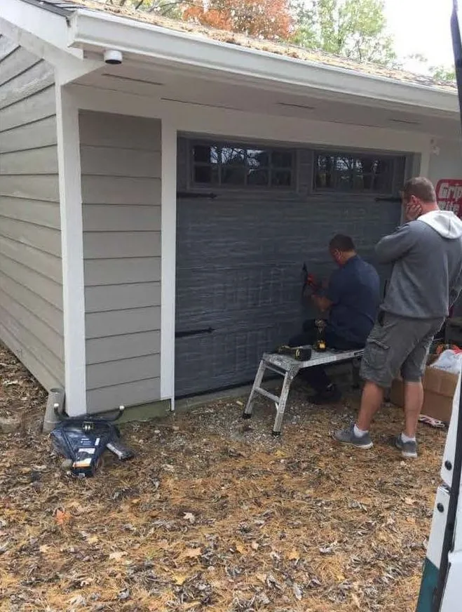 The Two Women Contractors crew installing hardware on a new carriage style garage door