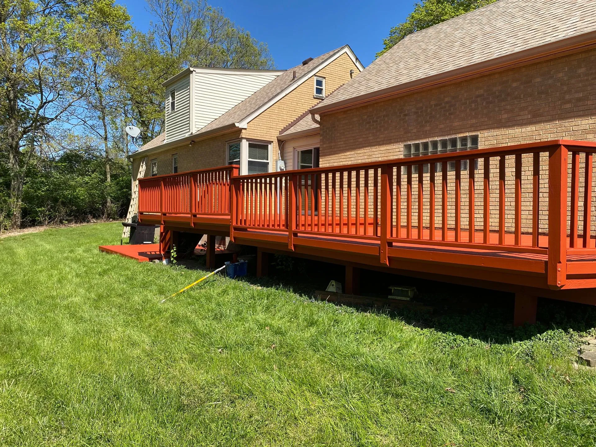 Deck staining and building services — a multi-level backyard deck with fresh stain