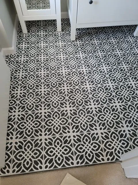 Black and white patterned encaustic floor tile in a remodeled bathroom