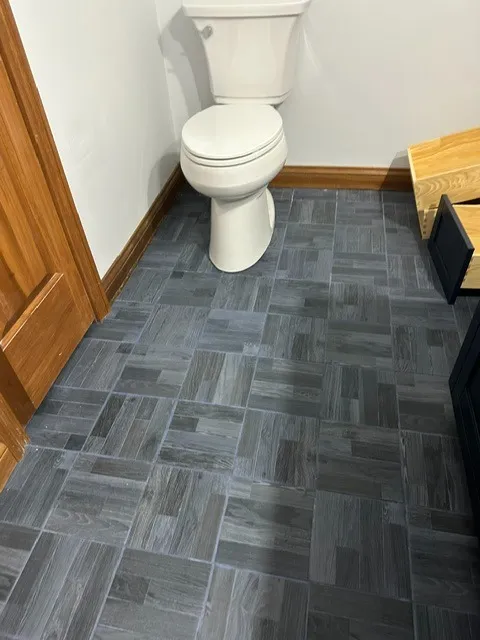 Grey wood-look porcelain tile laid in a parquet block pattern in a bathroom