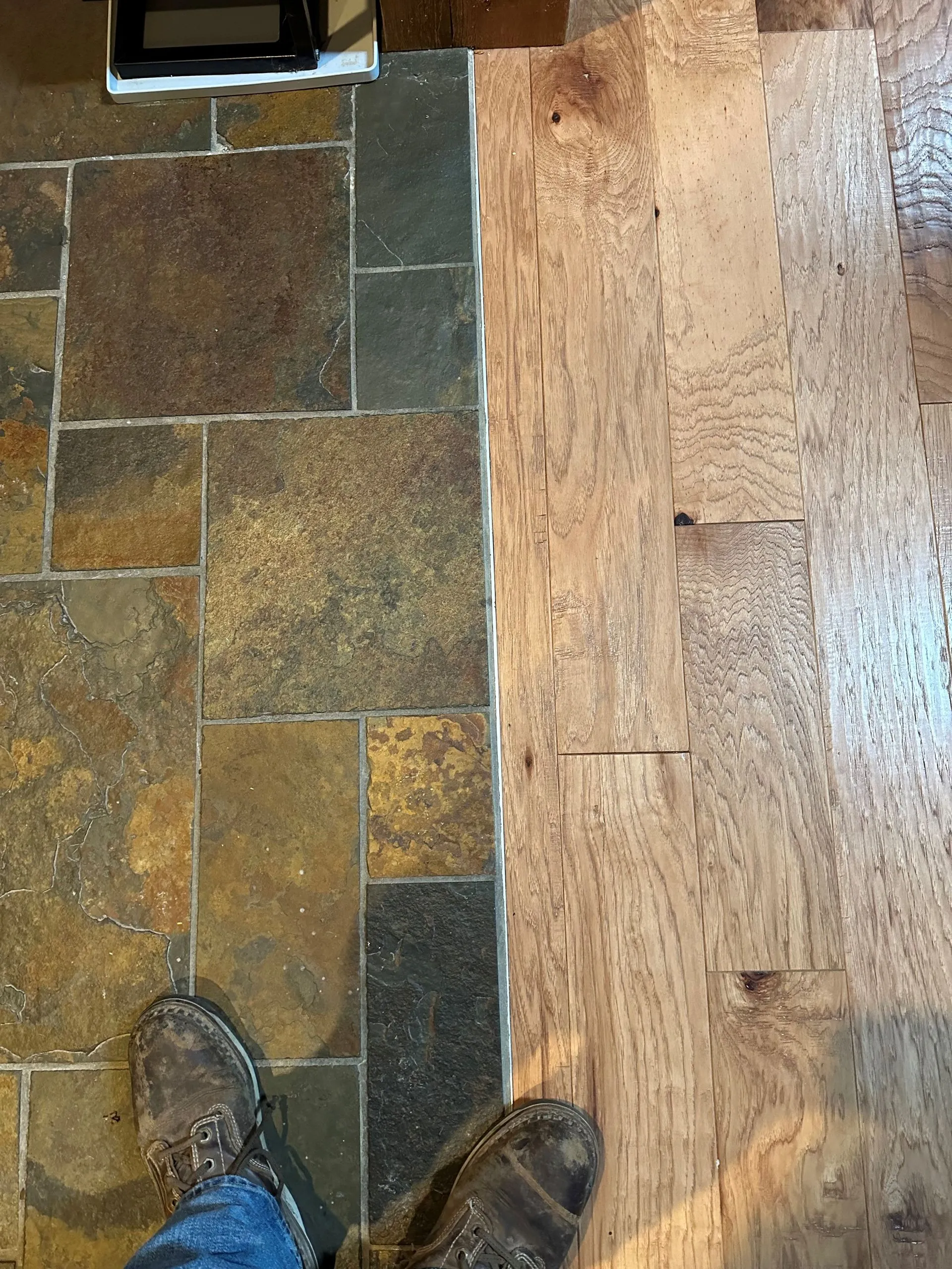 Slate tile meeting new hardwood flooring at a room transition