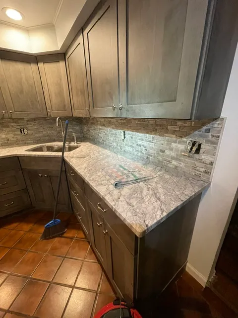 Dark kitchen cabinets under a speckled granite counter