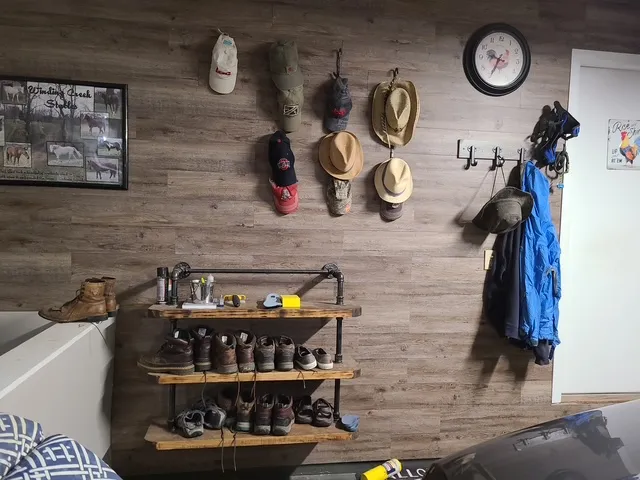 Mudroom with hooks, open shelving and a plank wall
