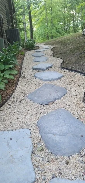 Flagstone stepping stone path set into pea gravel alongside a house