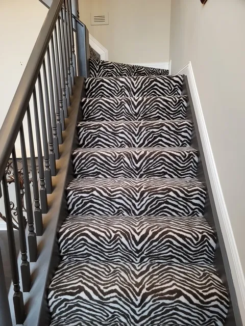 Staircase fitted with a black and white zebra-pattern runner