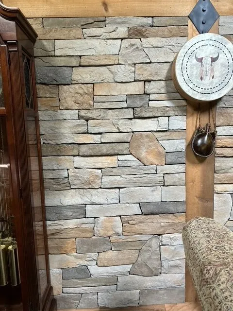 Interior dry stack stone veneer accent wall with rustic timber trim